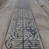 Des versets du Coran encadrent les portes. Ils ont été conçus en s'élargissant vers le sommet pour contrer l'effet d'optique de la perspective